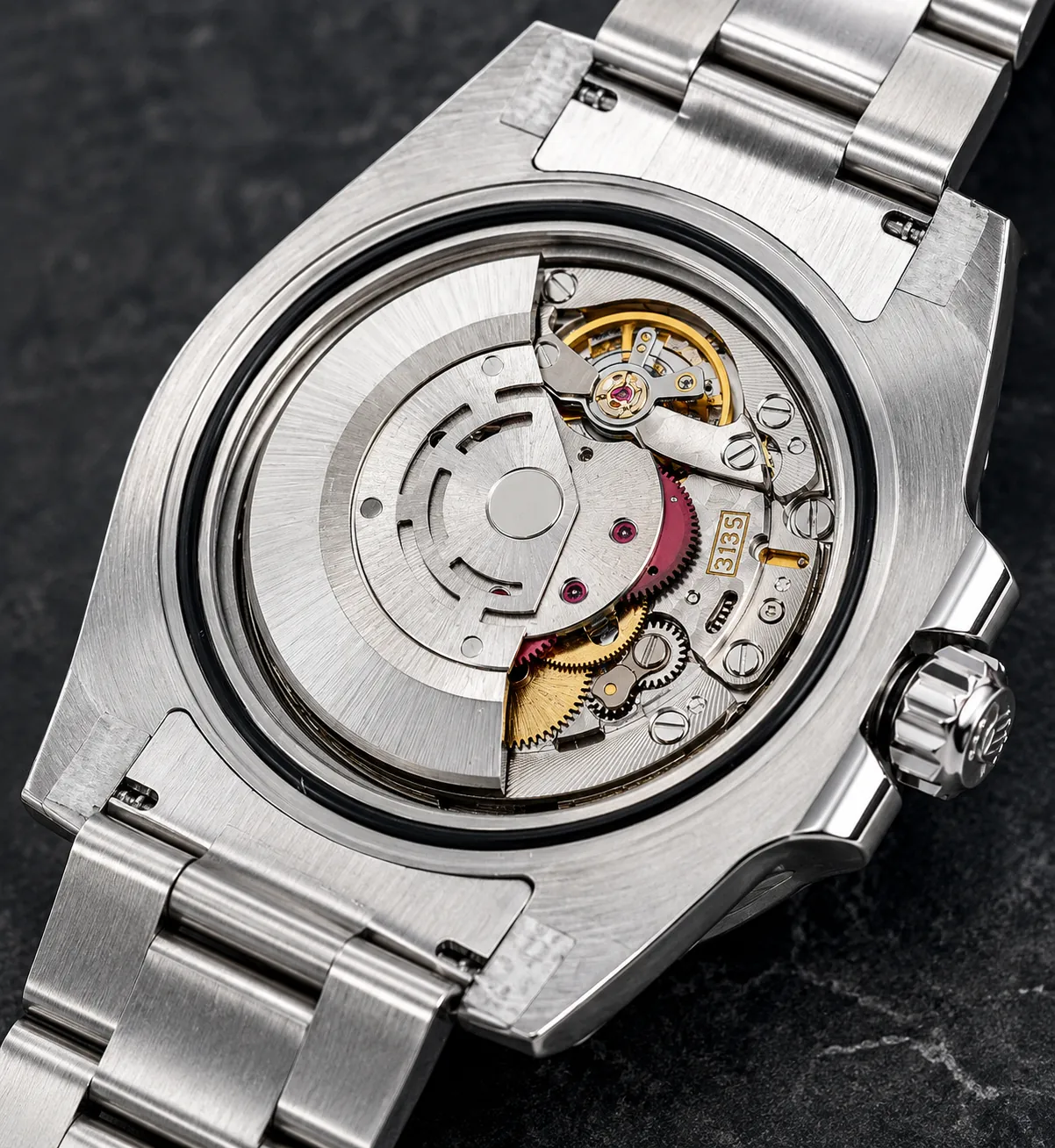 Detailed automatic watch movement with visible rotor and gears inside a stainless steel watch case.