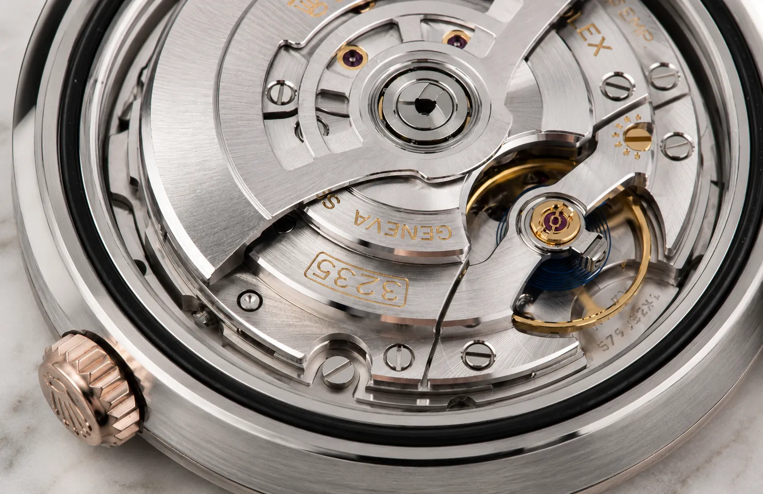 Macro close-up of a Rolex 3235 automatic movement featuring a precision rotor, balance wheel, jewel bearings, and finely finished mechanical components visible through the watch caseback.