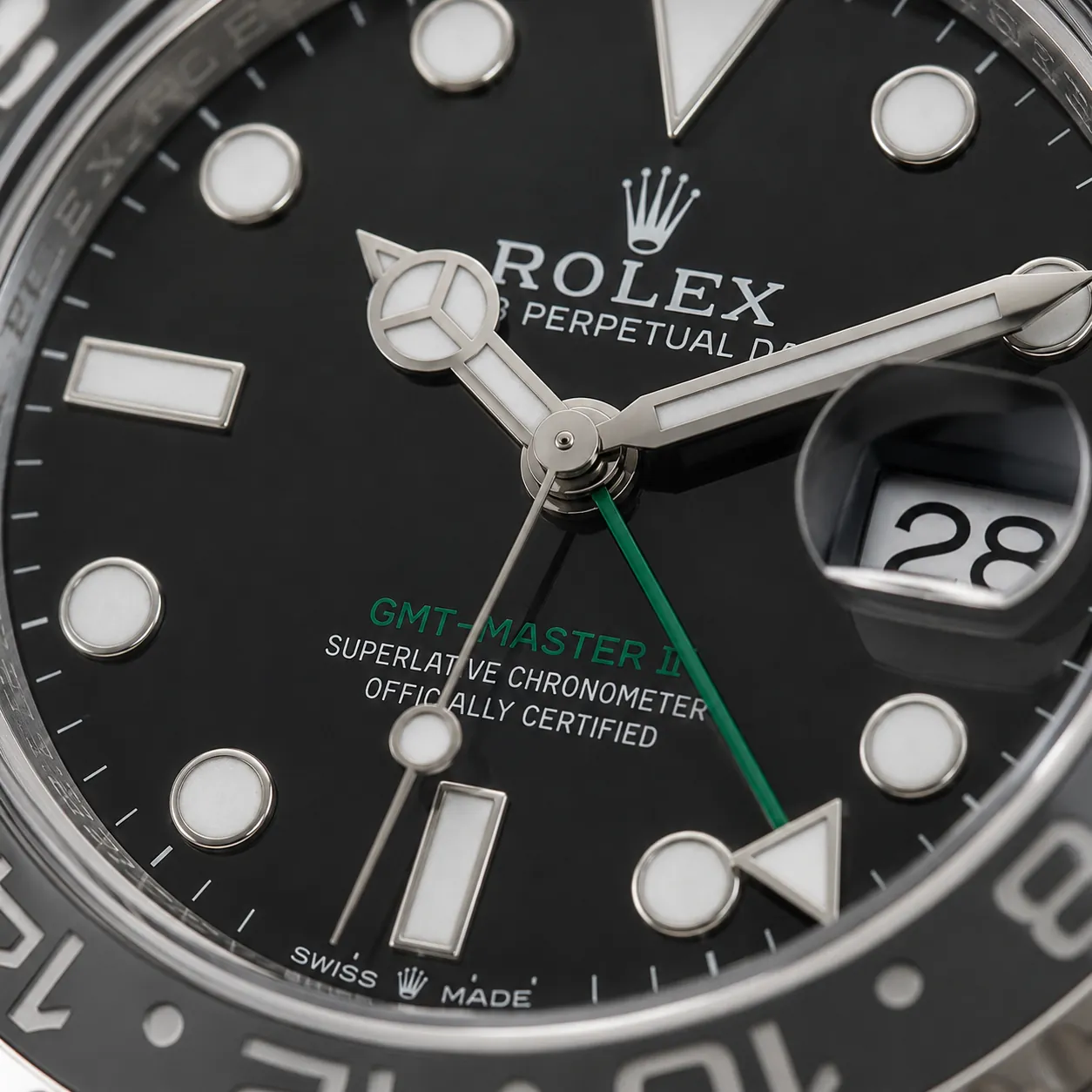 Detailed close-up of a Rolex GMT-Master II black dial with green GMT hand and magnified date display.